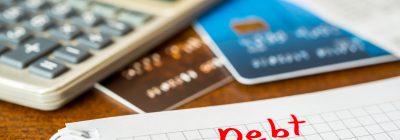 Debt payments, the calculation of the balance, a credit cards with checks and a calculator on the table